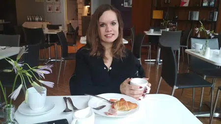 Женщина с чашкой кофе в кафе